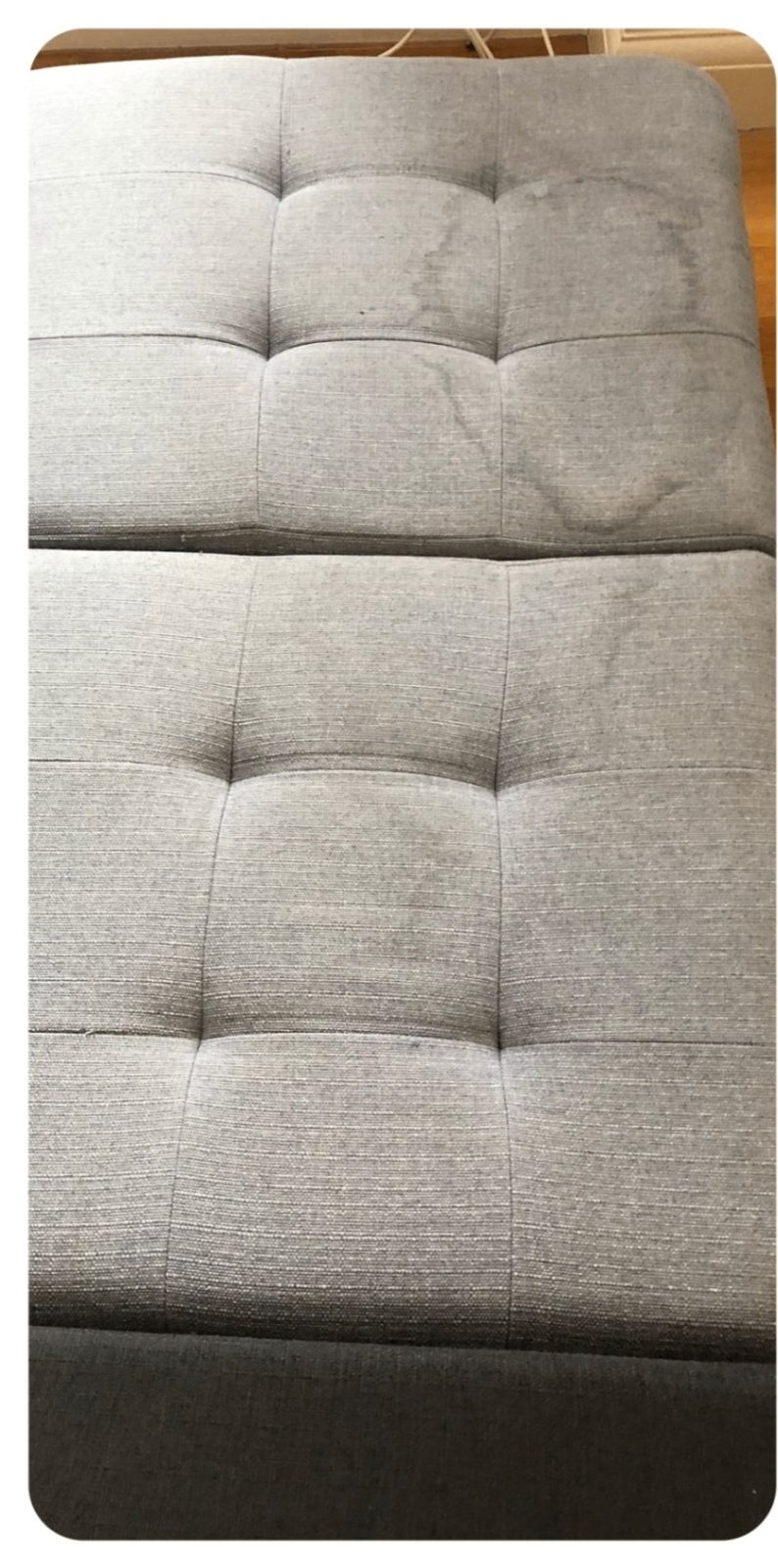 Grey fabric ottoman before cleaning with visible marks
